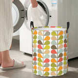 a woman is putting a laundry basket in front of a washing machine