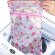 a woman putting a laundry bag into a washing machine