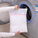 a person putting a towel into a washing machine