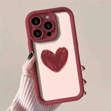 a woman holding a red heart phone case