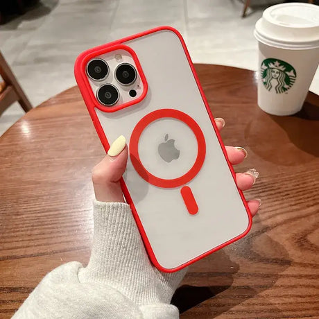 A woman holding a red iphone case with a white phone in the background