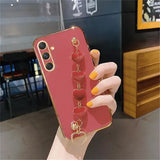 a woman holding a red phone case with a heart shaped ring