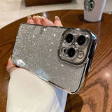 a woman holding a silver glitter iphone case