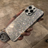 A woman holding a silver glitter phone case