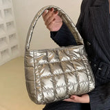 a woman holding a silver purse bag