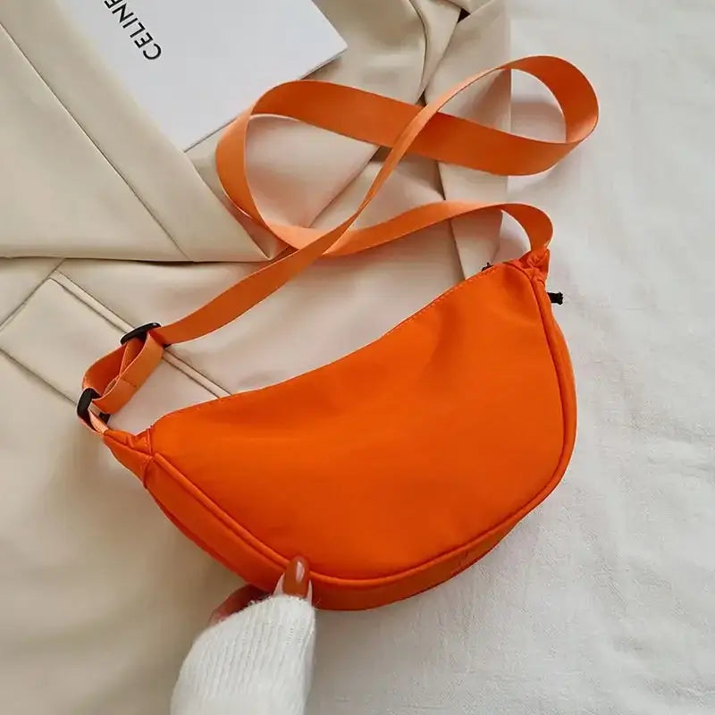 a woman holding a small orange bag