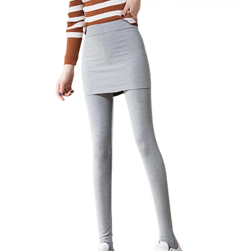 a woman wearing a striped sweater and grey leggings