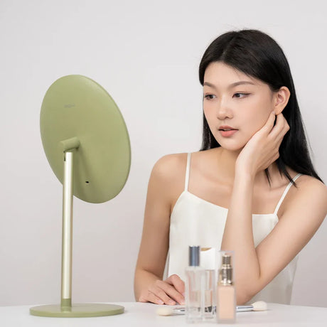 a woman sitting at a table with a mirror