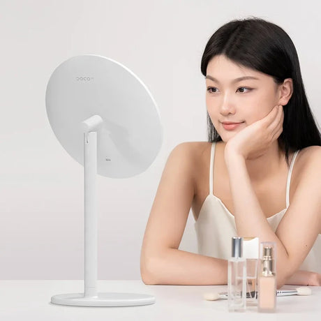 a woman sitting at a table with a mirror