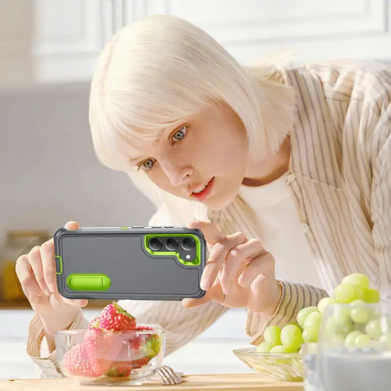 a woman is taking a picture of a fruit
