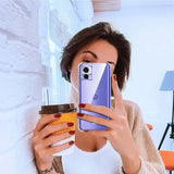 woman taking a selfie with her phone while holding a coffee