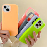 a woman holding three different colored cases