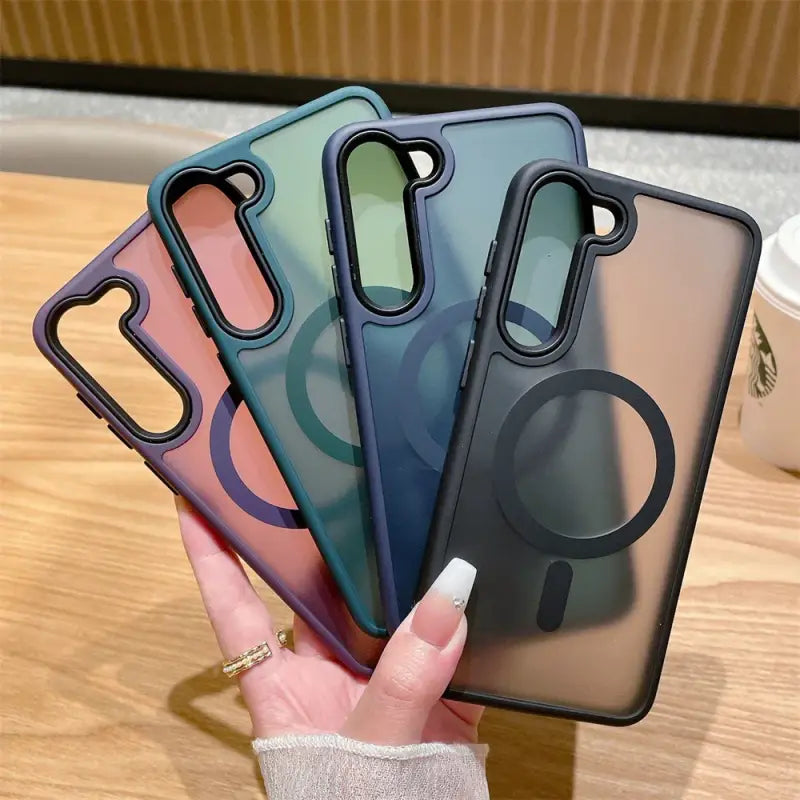 a woman holding up three iphone cases