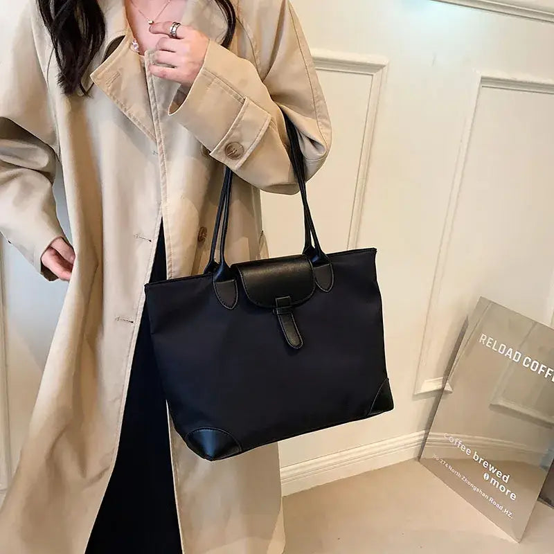 a woman wearing a trench coat and holding a black handbag