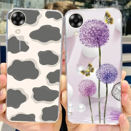 a woman holding up two cell cases with purple flowers