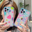 a woman holding up two colorful phone cases