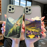 a woman holding two iphone cases with a mountain scene