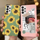 a woman holding up two iphone cases with sunflowers on them