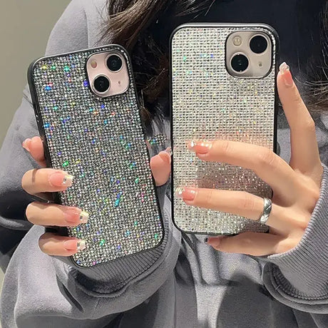 a woman holding two iphone cases with silver glitter