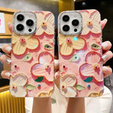 a woman holding up two iphone cases with flowers on them