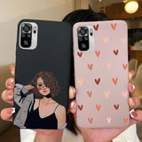 a woman holding up two iphone cases with hearts on them
