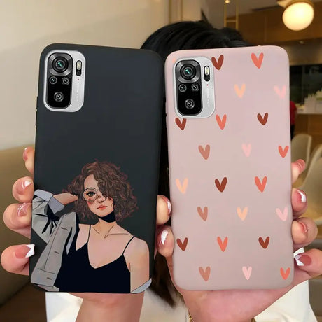 a woman holding up two iphone cases with hearts on them