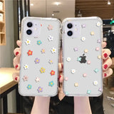 a woman holding two iphone cases with flowers on them