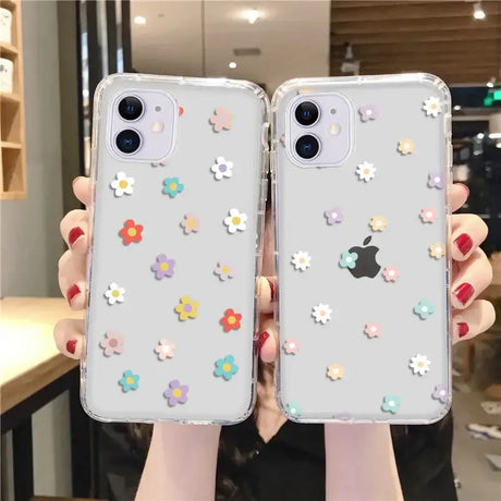 A woman holding two iphone cases with flowers on them