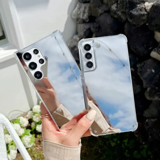 a woman holding up two iphones with a clear case