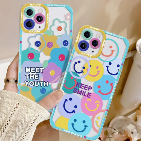 a woman holding up two phone cases with smiley faces