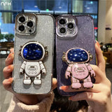 A woman holding up two phone cases with a spaceman and astronaut
