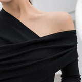 a woman wearing a black top with a long sleeve