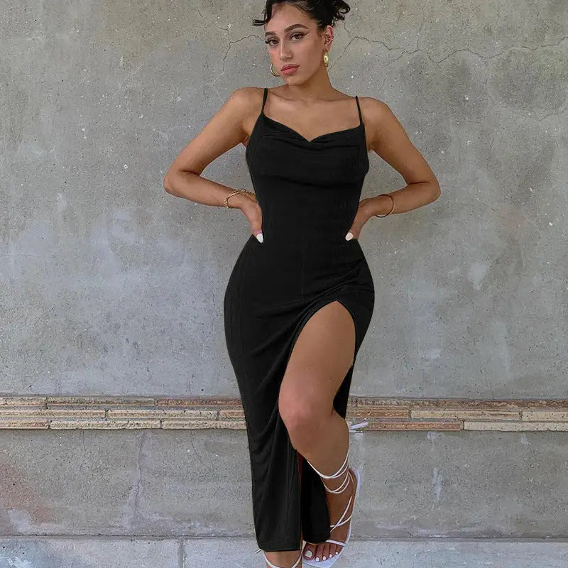 a woman in a black dress standing against a wall