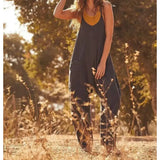 a woman in a black jumpsuit standing in a field