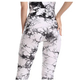 a woman wearing a black and white marble print leggings