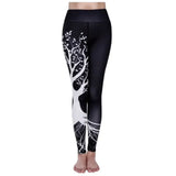 a woman wearing black and white yoga leggings with a tree design