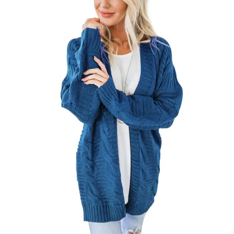 a woman wearing a blue cable knit cardigan sweater