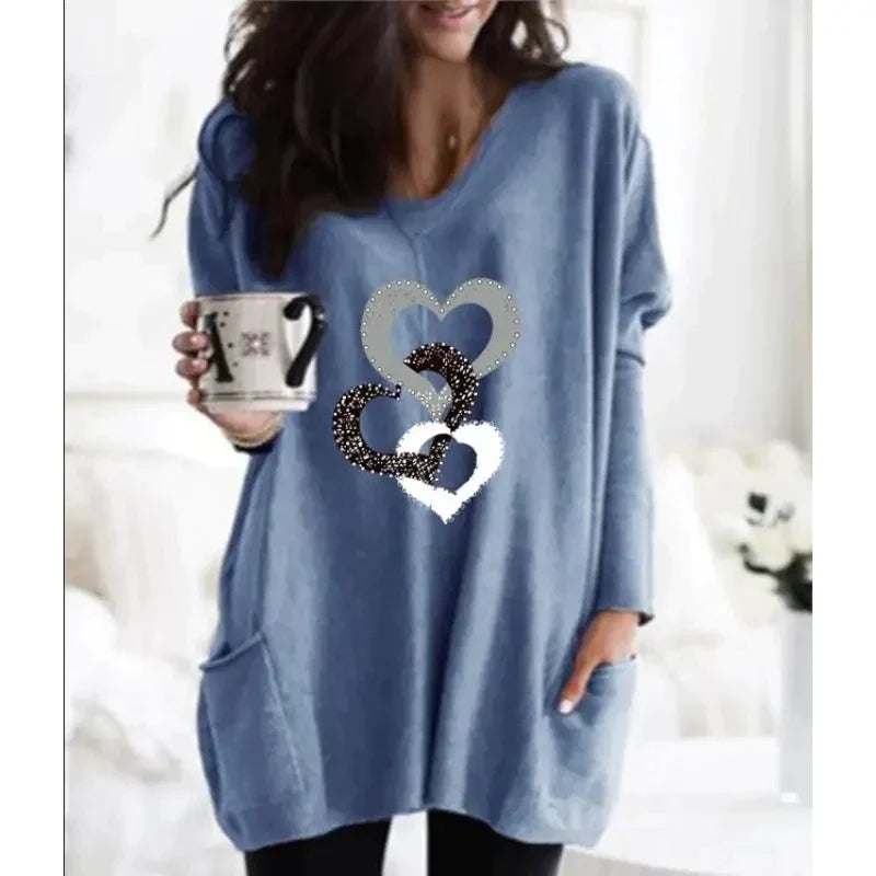 a woman wearing a blue sweater with a heart on it