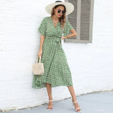 a woman wearing a green floral dress and hat