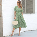 a woman wearing a green floral dress