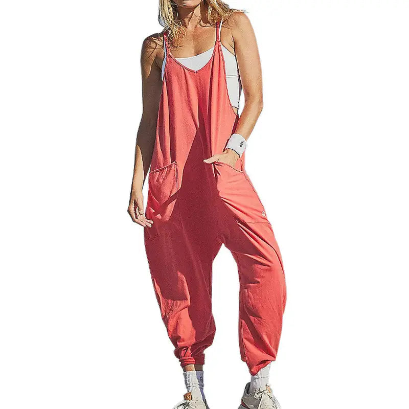 a woman in a pink jumpsuit with a white tank top and red pants