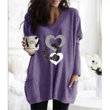 a woman wearing a purple sweater with a heart on it