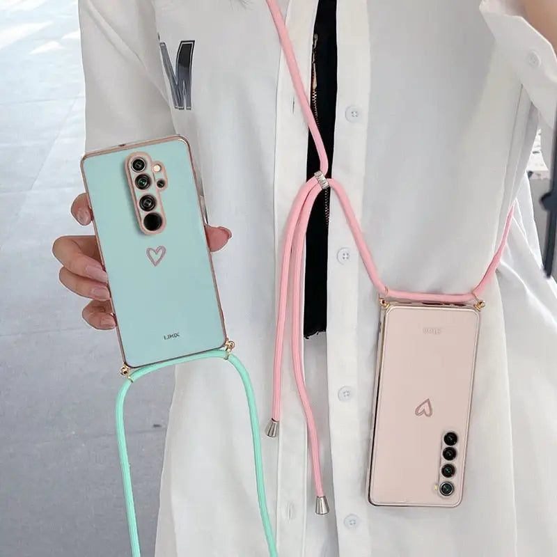 a woman wearing a white coat holding a pink and green phone case