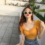 a woman wearing sunglasses and a yellow top