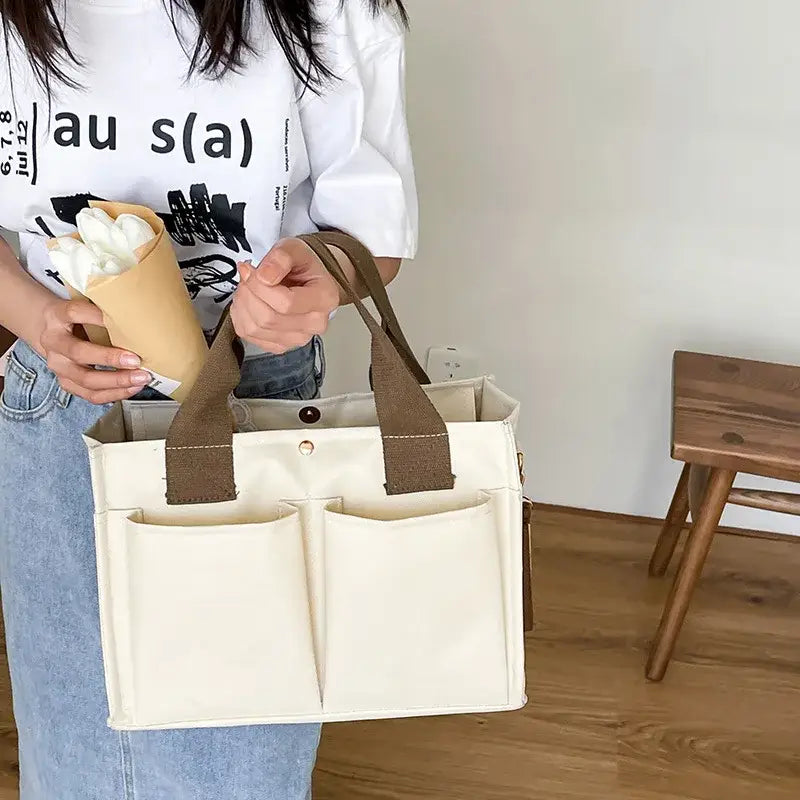 a woman holding a white bag with a brown handle