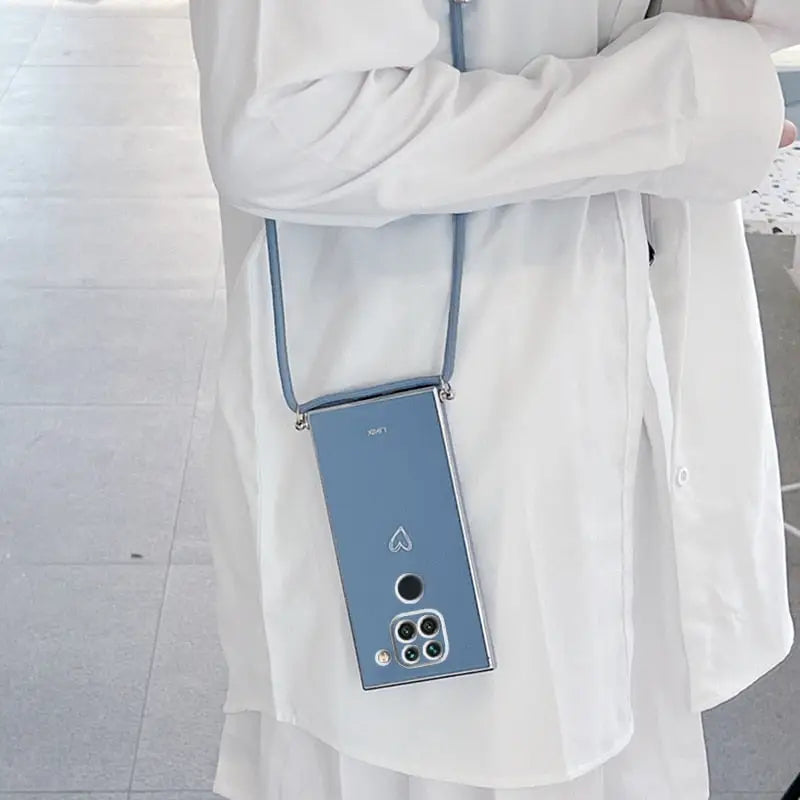 a woman wearing a white coat and holding a blue cell phone