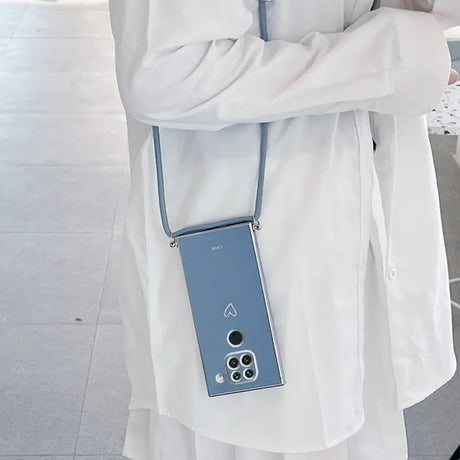 A woman wearing a white coat and holding a blue cell phone