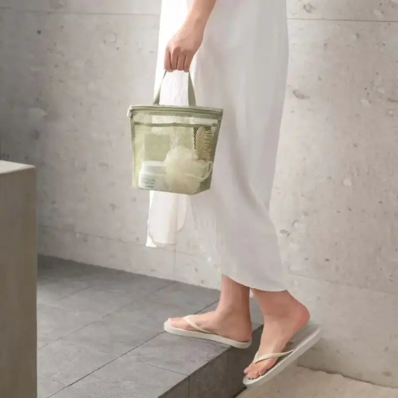 a woman in a white dress and green bag