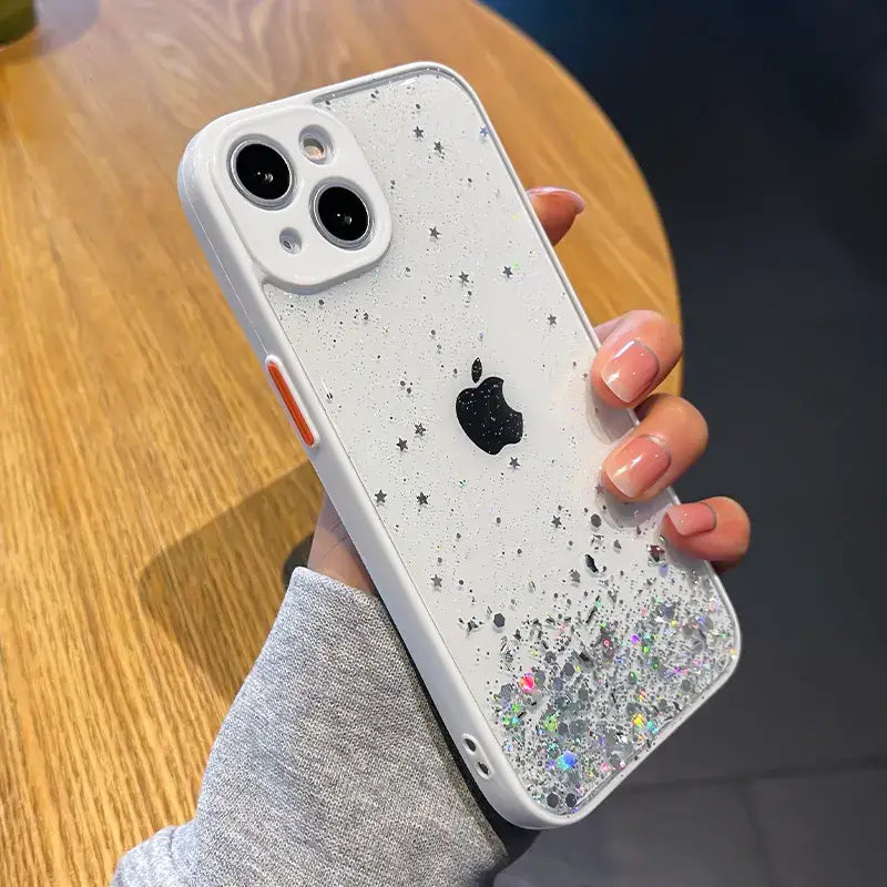 a woman holding a white iphone case with glitter stars on it