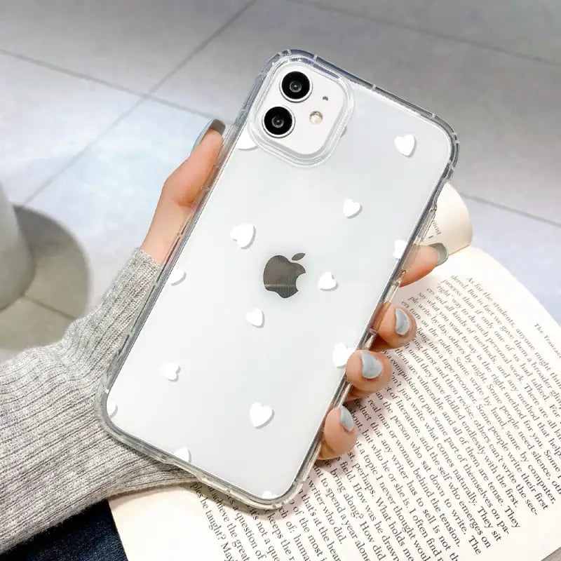 a woman holding a white iphone case with holes